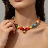 Colorful Heart Pendant Beaded Collarbone Necklace worn by a woman, showcasing vibrant beads and a gold heart charm.